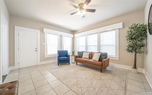 sitting room with light tile patterned flooring, baseboards, and ceiling fan