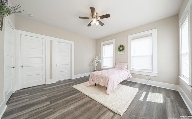 bedroom with baseboards, dark wood-type flooring, and a ceiling fan