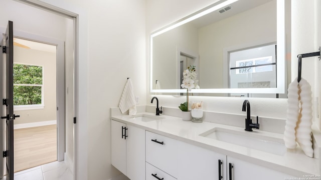 bathroom featuring double vanity, a sink, and visible vents