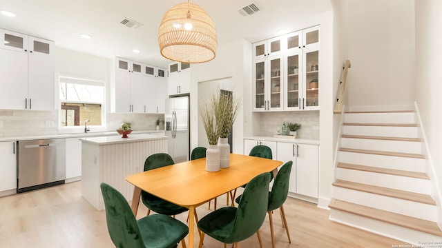 dining room with light wood-style flooring, recessed lighting, stairway, and visible vents