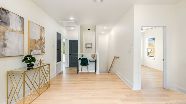 hallway with an upstairs landing, visible vents, baseboards, recessed lighting, and light wood-type flooring