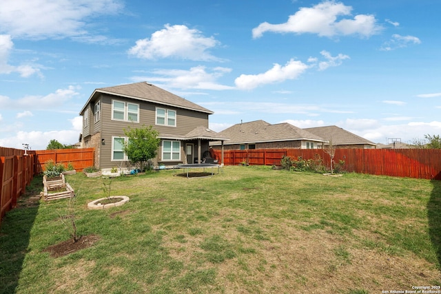 13850 Cohan Way, San Antonio, TX 78253 - rear view of house featuring a lawn, a trampoline, a vegetable garden, and a fenced backyard