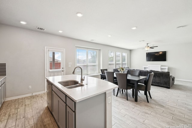 13850 Cohan Way, San Antonio, TX 78253 - kitchen with light countertops, dishwasher, wood finish floors, a ceiling fan, and a sink