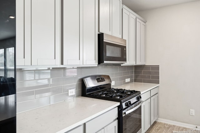 13850 Cohan Way, San Antonio, TX 78253 - kitchen with light stone countertops, stainless steel appliances, baseboards, light wood-style floors, and decorative backsplash