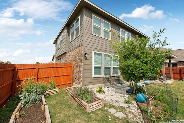 13850 Cohan Way, San Antonio, TX 78253 - back of house featuring a fenced backyard, brick siding, and a garden