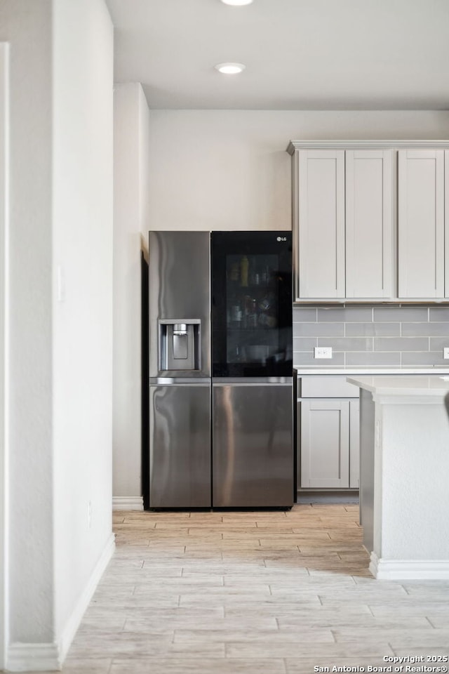13850 Cohan Way, San Antonio, TX 78253 - kitchen featuring light countertops, stainless steel fridge, baseboards, backsplash, and light wood-style floors
