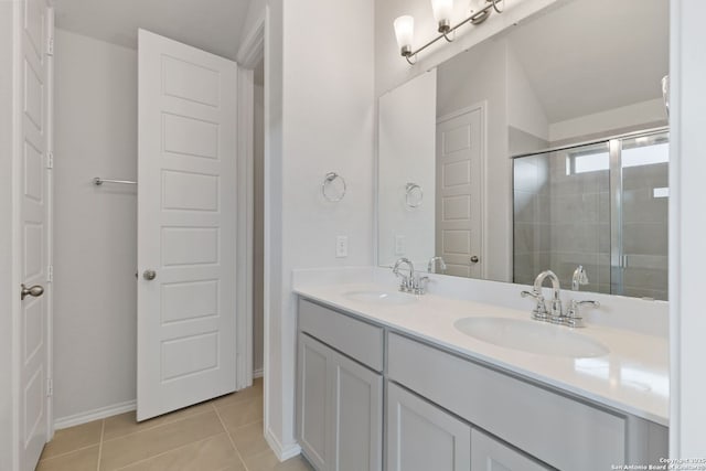 bathroom featuring a tile shower, tile patterned floors, double vanity, and a sink