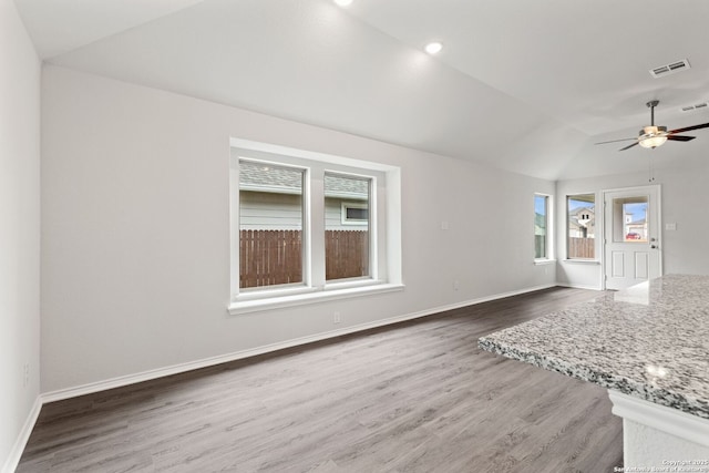 unfurnished living room featuring visible vents, baseboards, vaulted ceiling, and wood finished floors