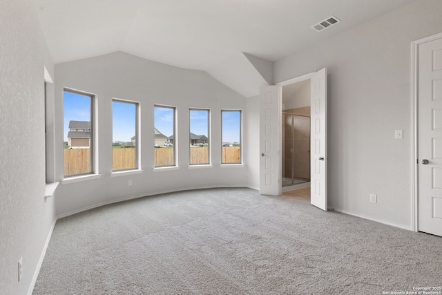unfurnished bedroom with carpet, visible vents, baseboards, and lofted ceiling