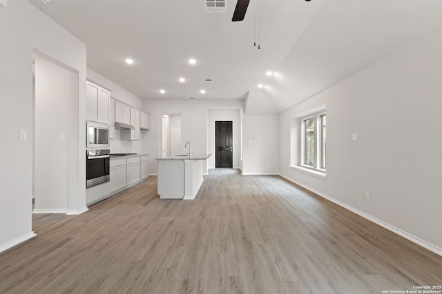 kitchen featuring open floor plan, built in microwave, visible vents, ceiling fan, and oven