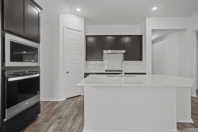 10281 Bartenheim Dr, Schertz, TX 78154 - kitchen featuring oven, built in microwave, light stone counters, dark wood-style flooring, and recessed lighting