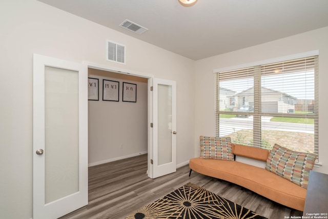 living area featuring wood finished floors, baseboards, and visible vents