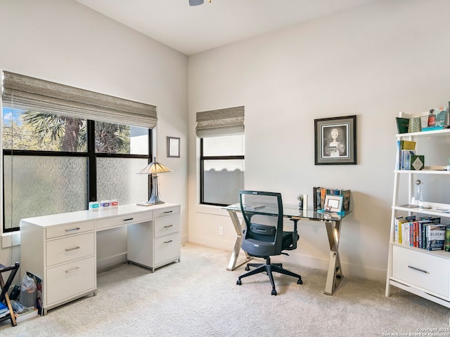 home office with baseboards and light colored carpet