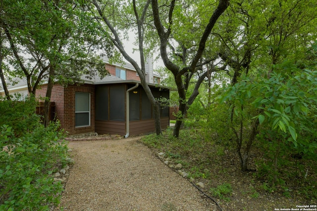 7609 Highland Park, San Antonio, TX 78250 - view of side of property featuring brick siding and a sunroom