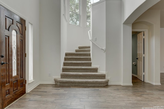 7609 Highland Park, San Antonio, TX 78250 - foyer featuring arched walkways, stairs, wood finished floors, and baseboards