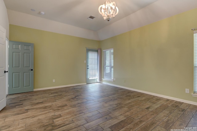 7609 Highland Park, San Antonio, TX 78250 - unfurnished room featuring wood finished floors, a chandelier, lofted ceiling, baseboards, and a smoke detector