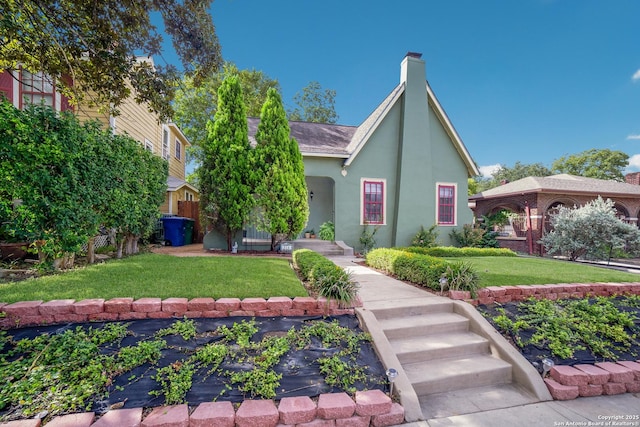 view of front of property with a chimney, stucco siding, and a front lawn