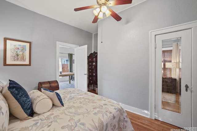 bedroom featuring a ceiling fan, baseboards, and wood finished floors