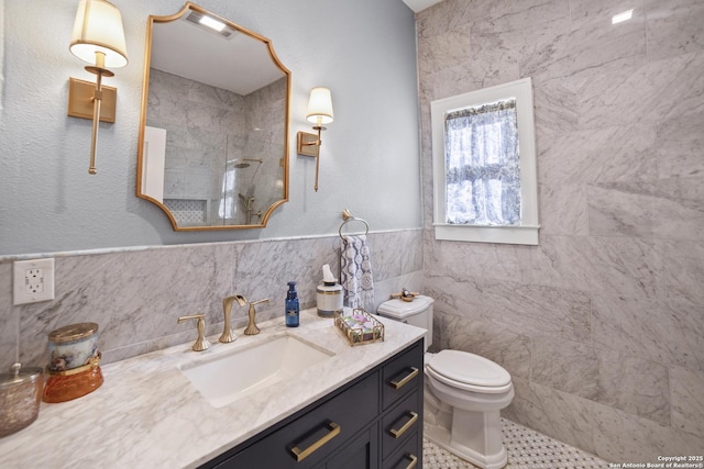 full bath featuring toilet, vanity, tile walls, and a tile shower