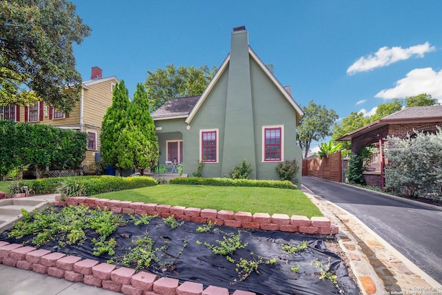 view of front of house featuring a front yard, stucco siding, and fence