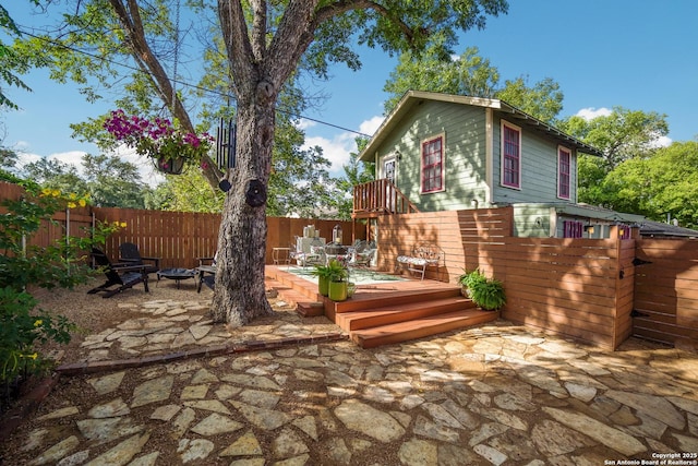 view of patio / terrace featuring fence, a fire pit, and a deck