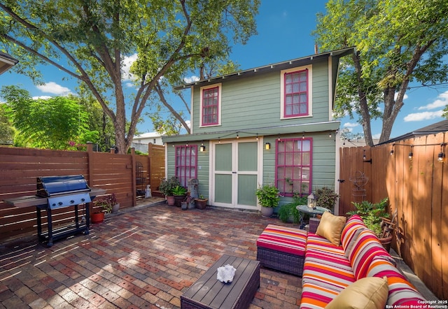 exterior space with area for grilling, a patio, a fenced backyard, outdoor lounge area, and an outdoor structure