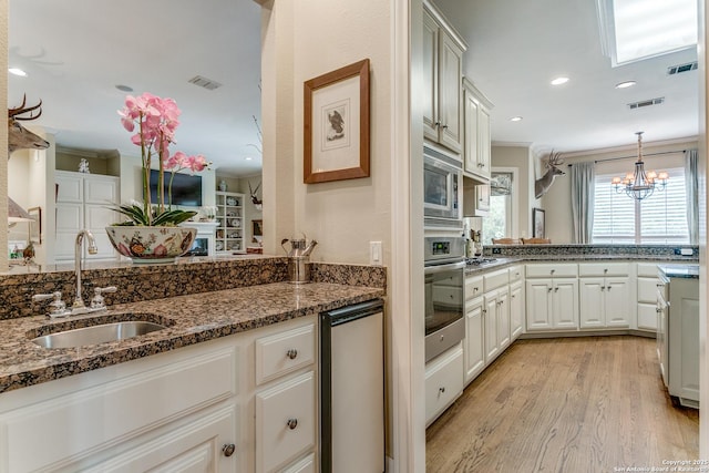 93 Bristol Grn, San Antonio, TX 78209 - kitchen with stainless steel appliances, a sink, light wood-type flooring, visible vents, and ornamental molding