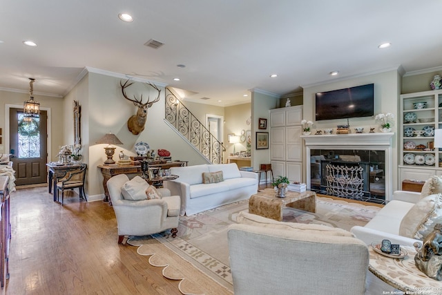 93 Bristol Grn, San Antonio, TX 78209 - living room featuring stairway, light wood finished floors, a tiled fireplace, visible vents, and recessed lighting