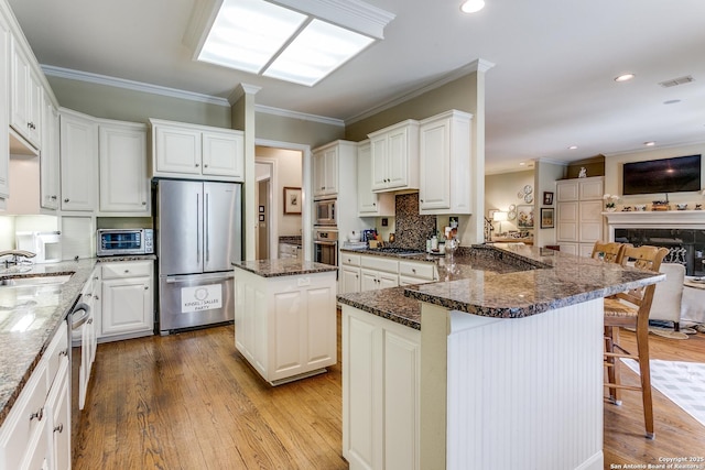 93 Bristol Grn, San Antonio, TX 78209 - kitchen with tasteful backsplash, light wood-style flooring, a peninsula, appliances with stainless steel finishes, and visible vents