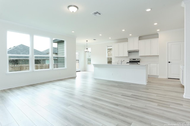 5230 Anzueto, San Antonio, TX 78261 - kitchen with visible vents, stainless steel electric range, under cabinet range hood, open floor plan, and an inviting chandelier