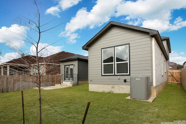 5230 Anzueto, San Antonio, TX 78261 - rear view of house with a fenced backyard, central AC unit, and a lawn