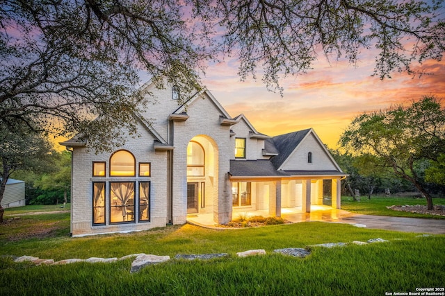 162 Teal Rdg, Canyon Lake, TX 78133 - view of front facade featuring concrete driveway, brick siding, and a yard