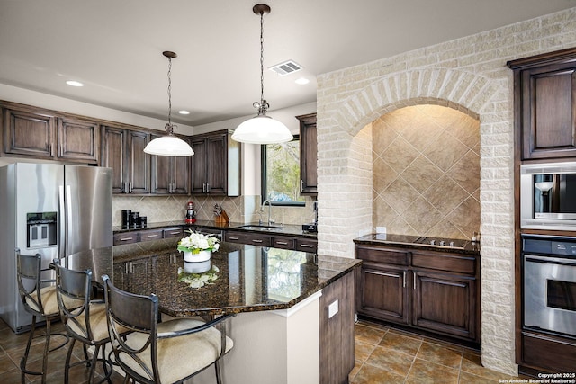 162 Teal Rdg, Canyon Lake, TX 78133 - kitchen featuring dark brown cabinetry, backsplash, a sink, stainless steel appliances, and visible vents