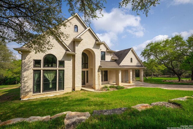 162 Teal Rdg, Canyon Lake, TX 78133 - view of front facade with brick siding, concrete driveway, and a front yard