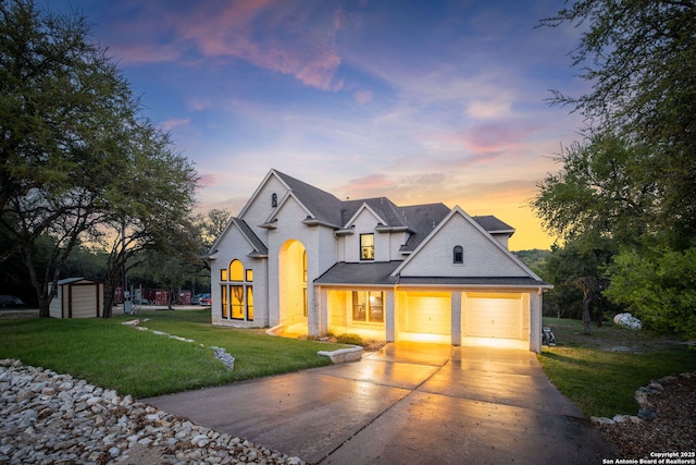162 Teal Rdg, Canyon Lake, TX 78133 - view of front of house featuring driveway, brick siding, a front lawn, a storage unit, and a garage