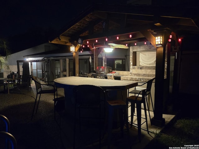 patio at night with a gazebo and outdoor dining space