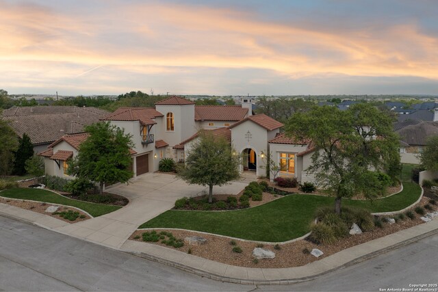 3919 El Chamizal, San Antonio, TX 78261 - mediterranean / spanish home with a tile roof, concrete driveway, stucco siding, a front yard, and a garage