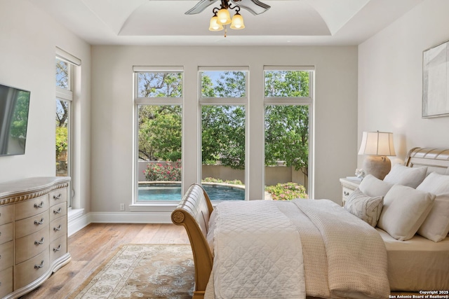 3919 El Chamizal, San Antonio, TX 78261 - bedroom with a tray ceiling, light wood-style floors, and baseboards