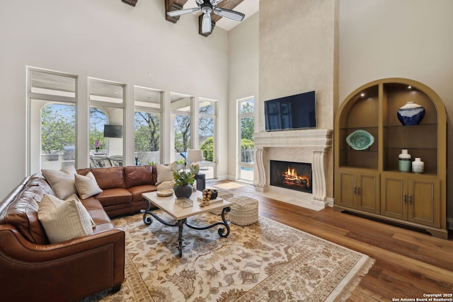 3919 El Chamizal, San Antonio, TX 78261 - living area featuring a fireplace, a high ceiling, wood finished floors, and a ceiling fan