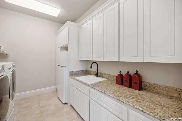 3919 El Chamizal, San Antonio, TX 78261 - clothes washing area featuring a sink, separate washer and dryer, light tile patterned floors, baseboards, and cabinet space