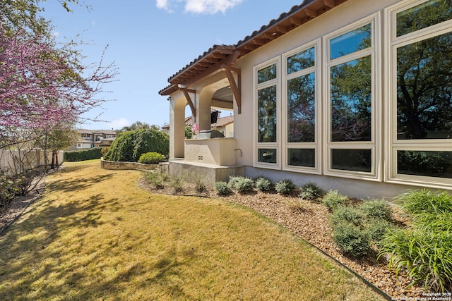 3919 El Chamizal, San Antonio, TX 78261 - view of side of property with stucco siding, a tiled roof, and a yard