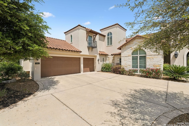 3919 El Chamizal, San Antonio, TX 78261 - mediterranean / spanish home featuring stone siding, a tiled roof, a garage, concrete driveway, and stucco siding