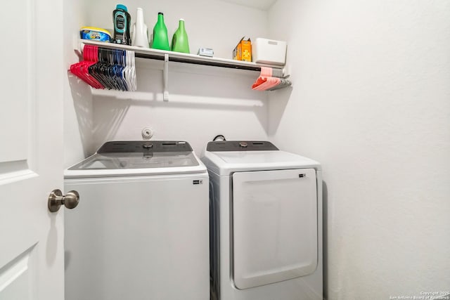 clothes washing area with washer and clothes dryer and laundry area