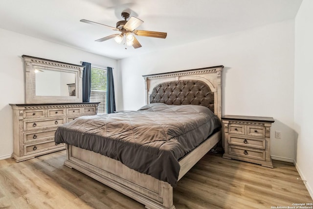 bedroom featuring baseboards, light wood-type flooring, and ceiling fan