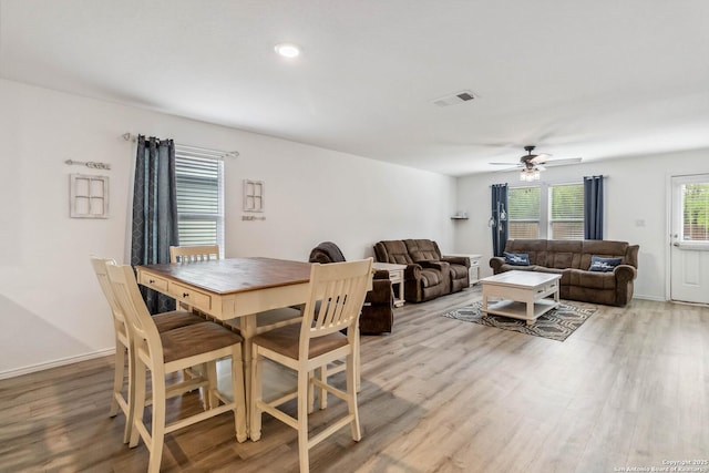 dining space with baseboards, ceiling fan, visible vents, and light wood-style floors