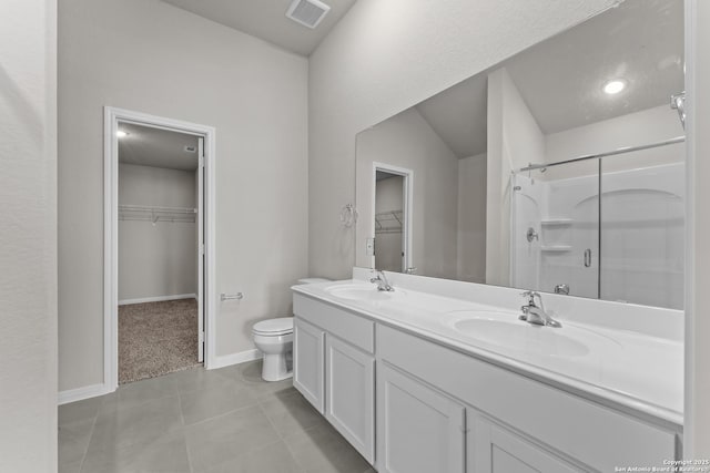 1542 Silver Run, New Braunfels, TX 78130 - bathroom featuring a walk in closet, a shower stall, double vanity, toilet, and tile patterned flooring
