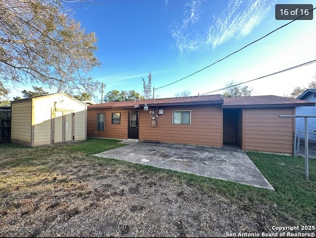 4223 Redstone Dr, San Antonio, TX 78219 - back of house featuring an outdoor structure, a lawn, a storage unit, and a patio