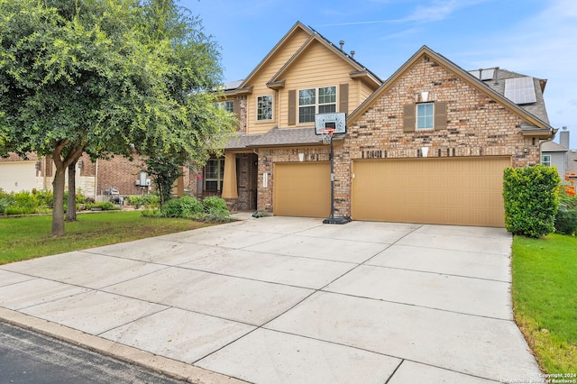 11331 Phoebe Lace, San Antonio, TX 78253 - view of front facade featuring solar panels, brick siding, a front lawn, concrete driveway, and an attached garage