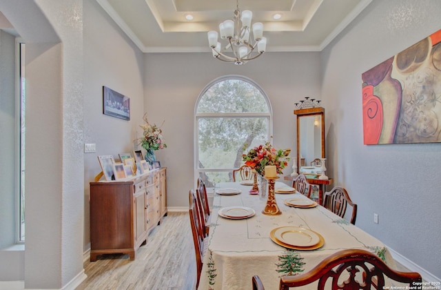 2110 Winding Vw, San Antonio, TX 78260 - dining area featuring a chandelier, arched walkways, light wood-style floors, and a raised ceiling
