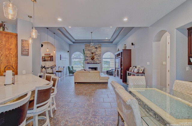 2110 Winding Vw, San Antonio, TX 78260 - dining area with a raised ceiling, a large fireplace, stone tile flooring, arched walkways, and recessed lighting